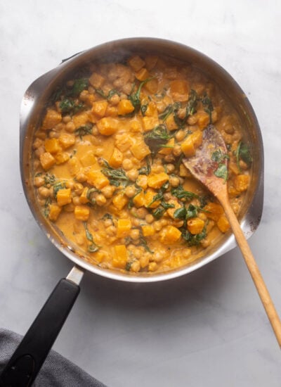 skillet with chickpeas and wilted spinach mixed with the rest of the curry ingredients.