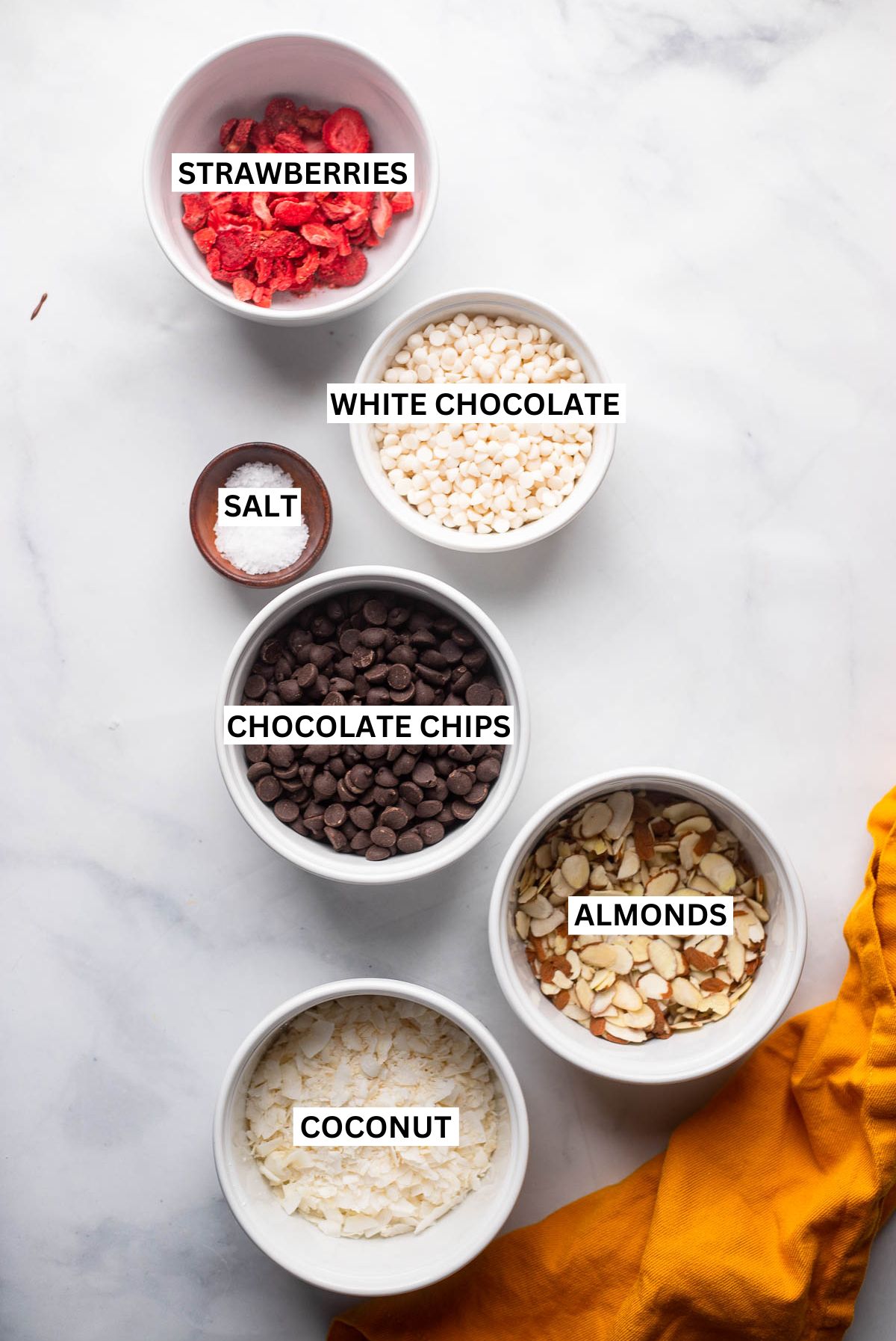 chocolate almond bark ingredients in small bowls with labels.