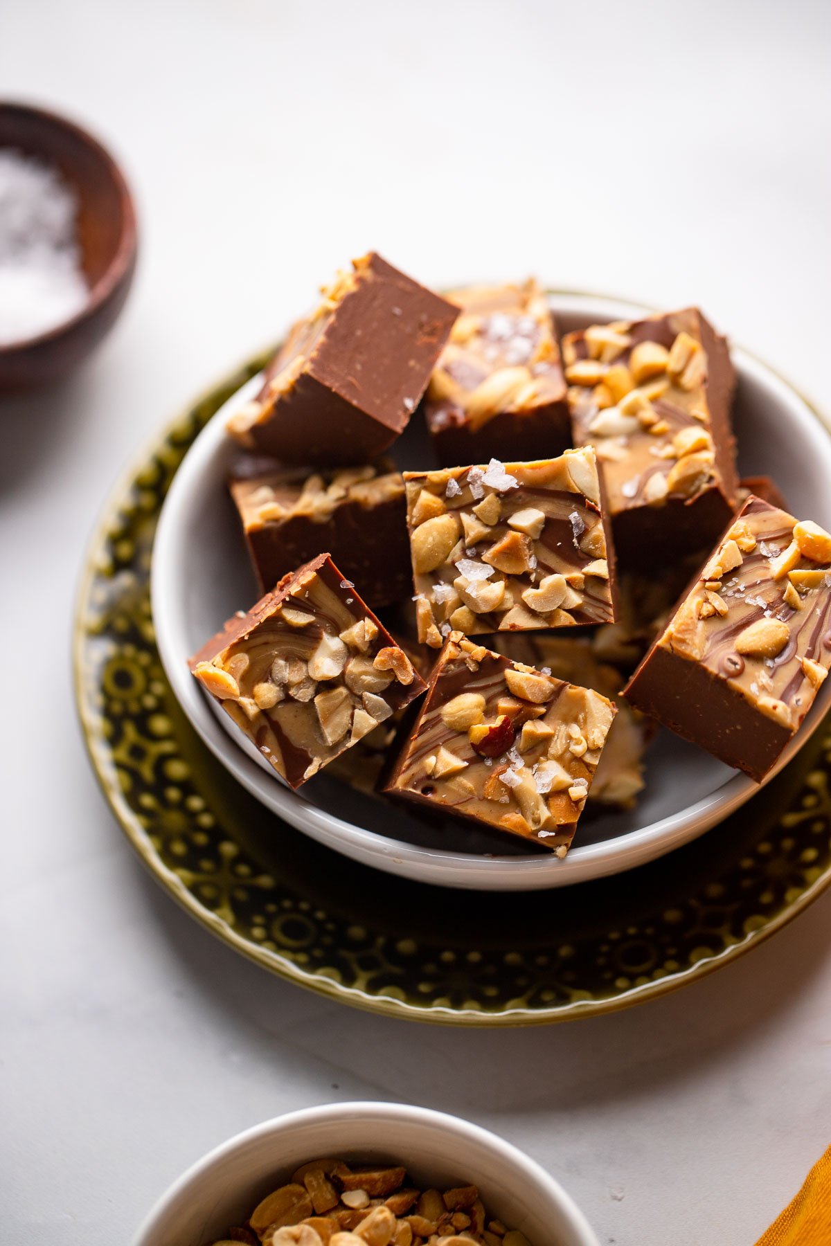 chocolate peanut butter fudge pieces in small dish garnished with sea salt.