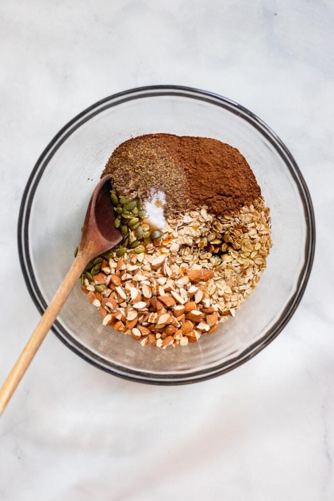 chocolate granola ingredients in mixing bowl before stirring.