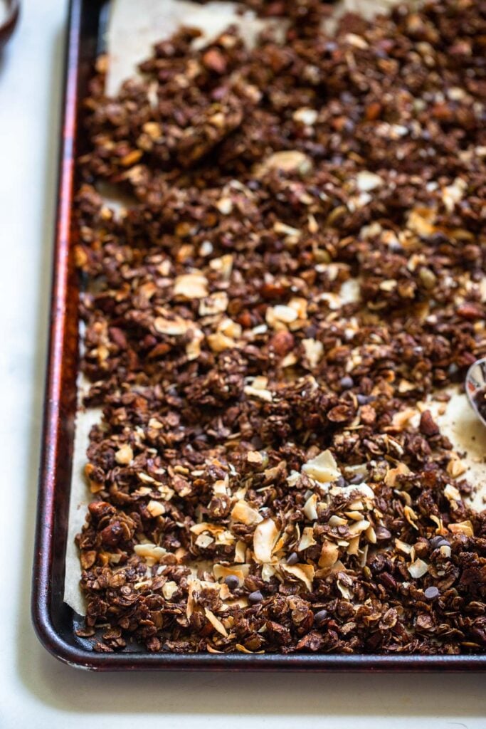 baked and cooled granola broken into chunks on a baking sheet.