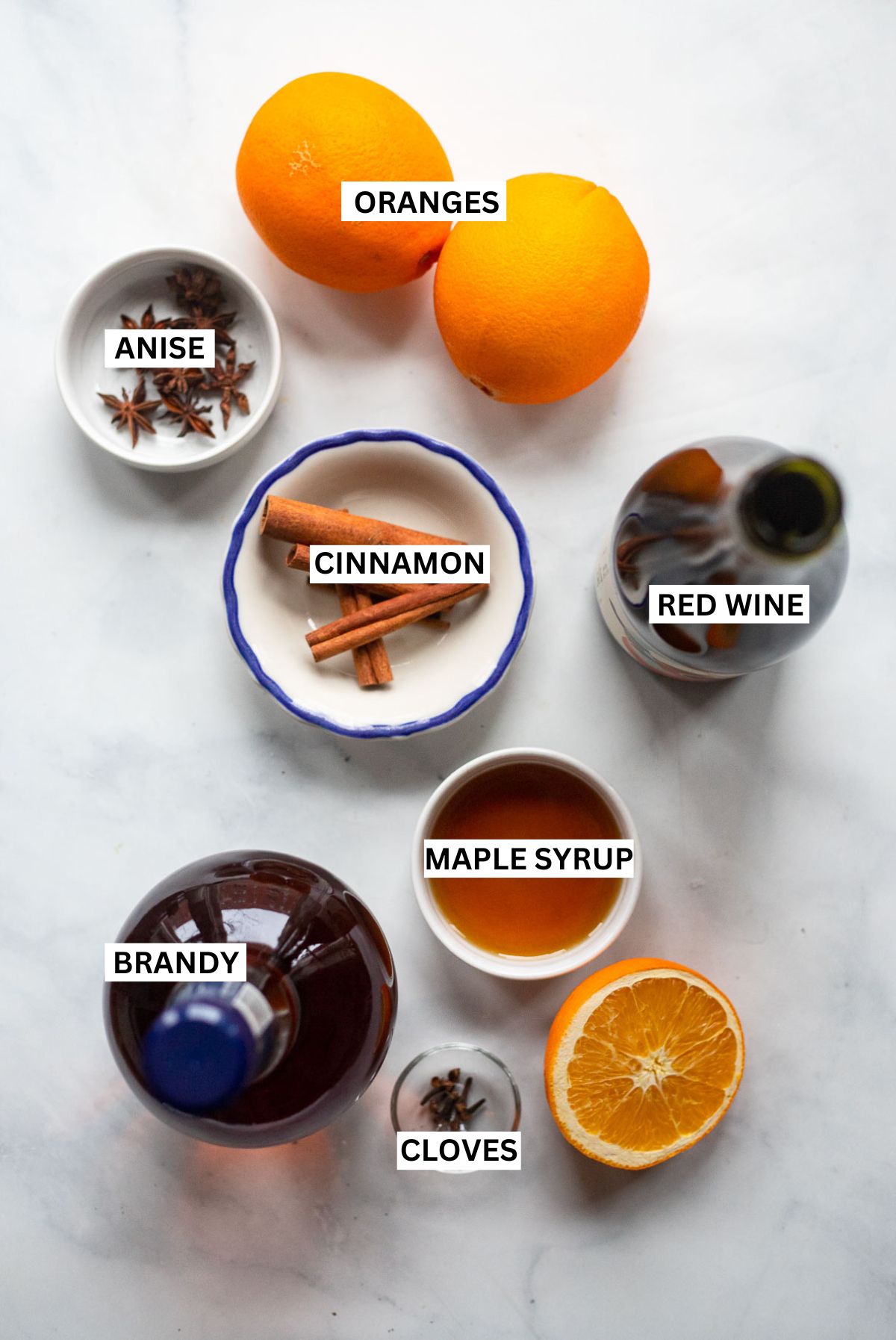 mulled wine ingredients laid out on white background with labels.