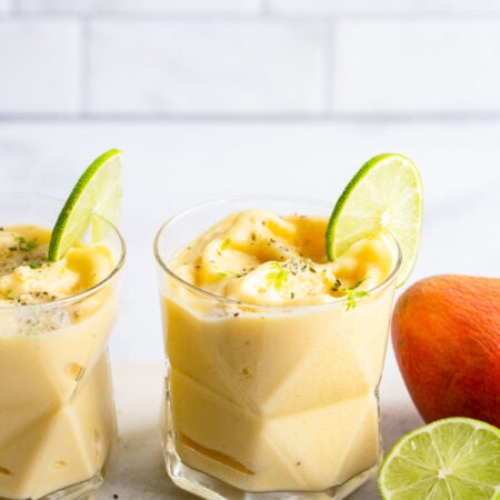 mango pineapple smoothie with slice of lime