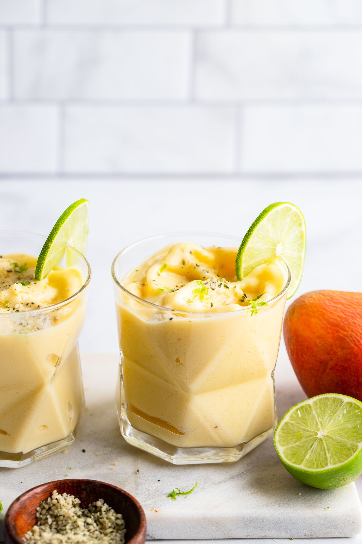 mango pineapple smoothie with slice of lime