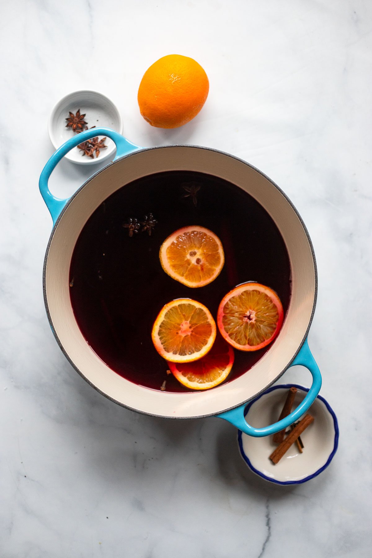 mulled wine in dutch oven with orange slices.