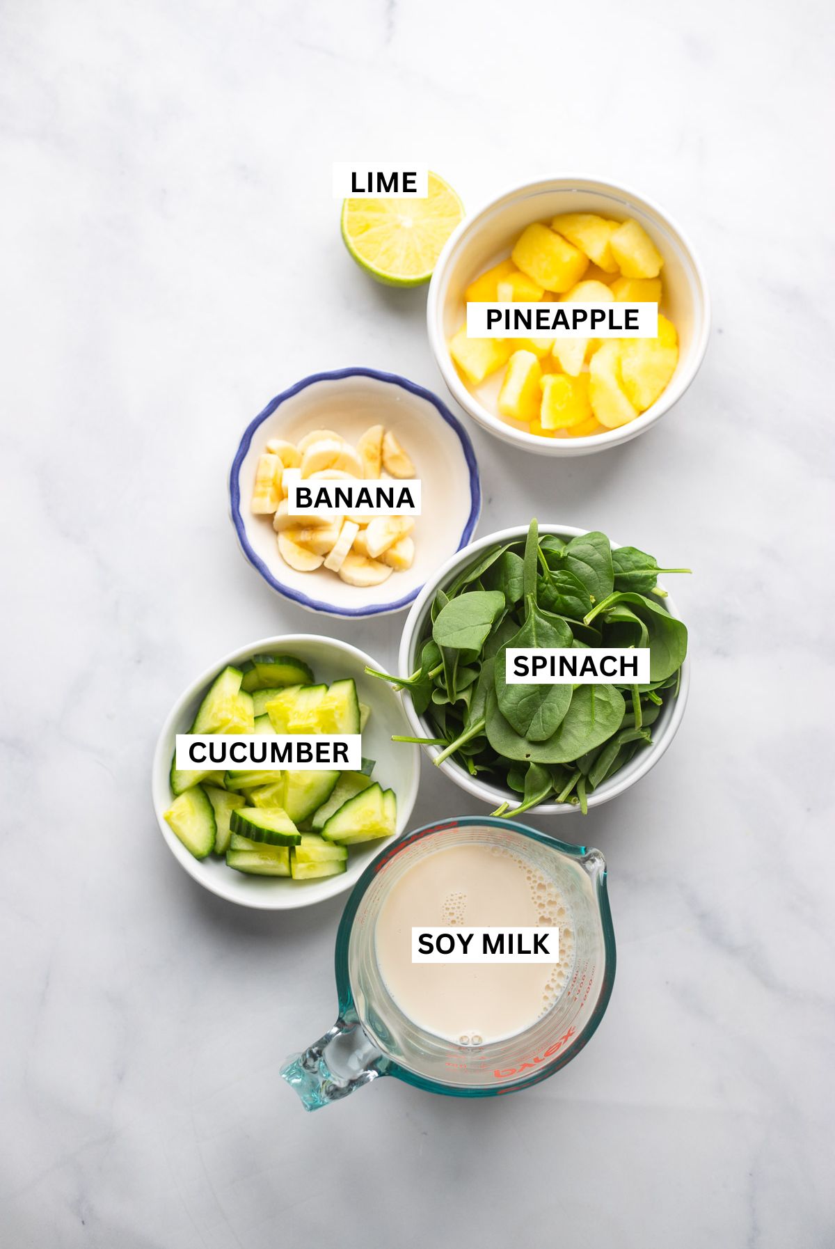pineapple cucumber smoothie ingredients in bowls with labels.