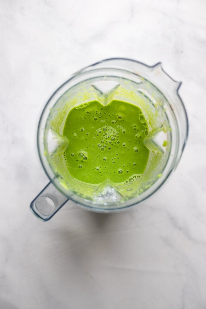 pureed green smoothie in blender pitcher.