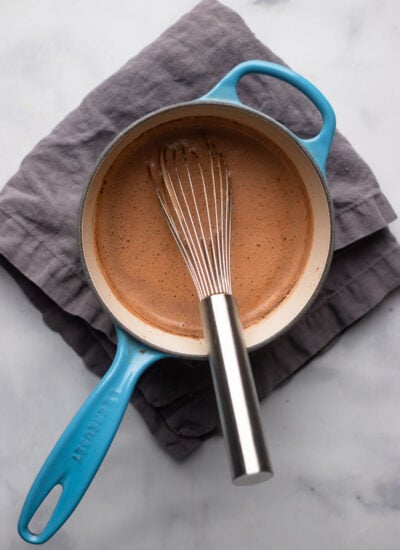 warm hot chocolate in saucepan with a whisk.