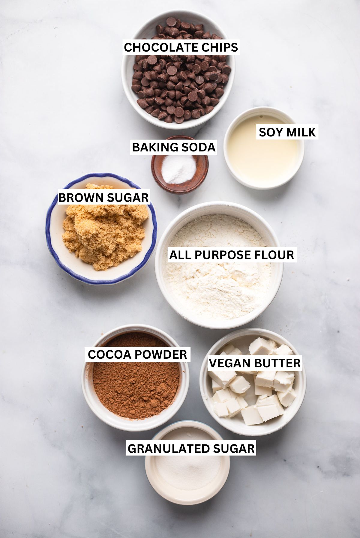 Zutaten für vegane Schokoladenkekse in kleinen Schalen mit Etiketten.