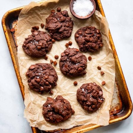 vegan double chocolate cookies on parchment lined baking sheet.