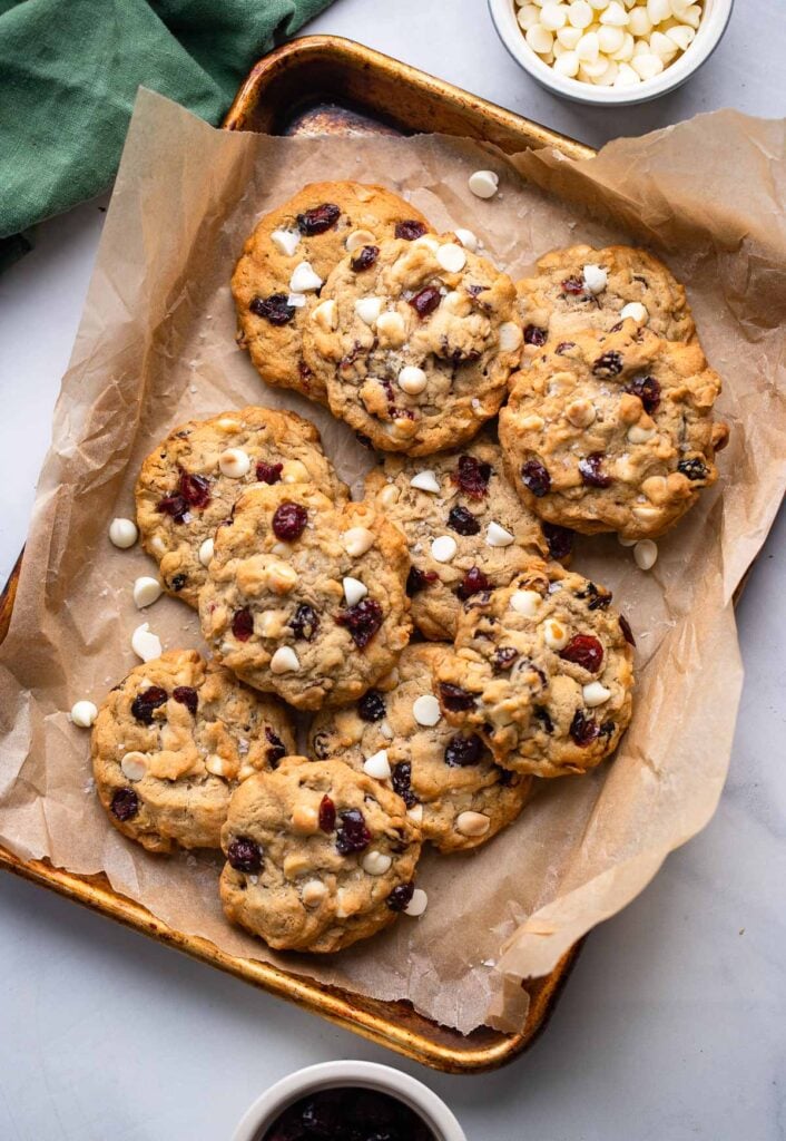 white chocolate cranberry oatmeal cookies on baking sheet lined with parchment paper.