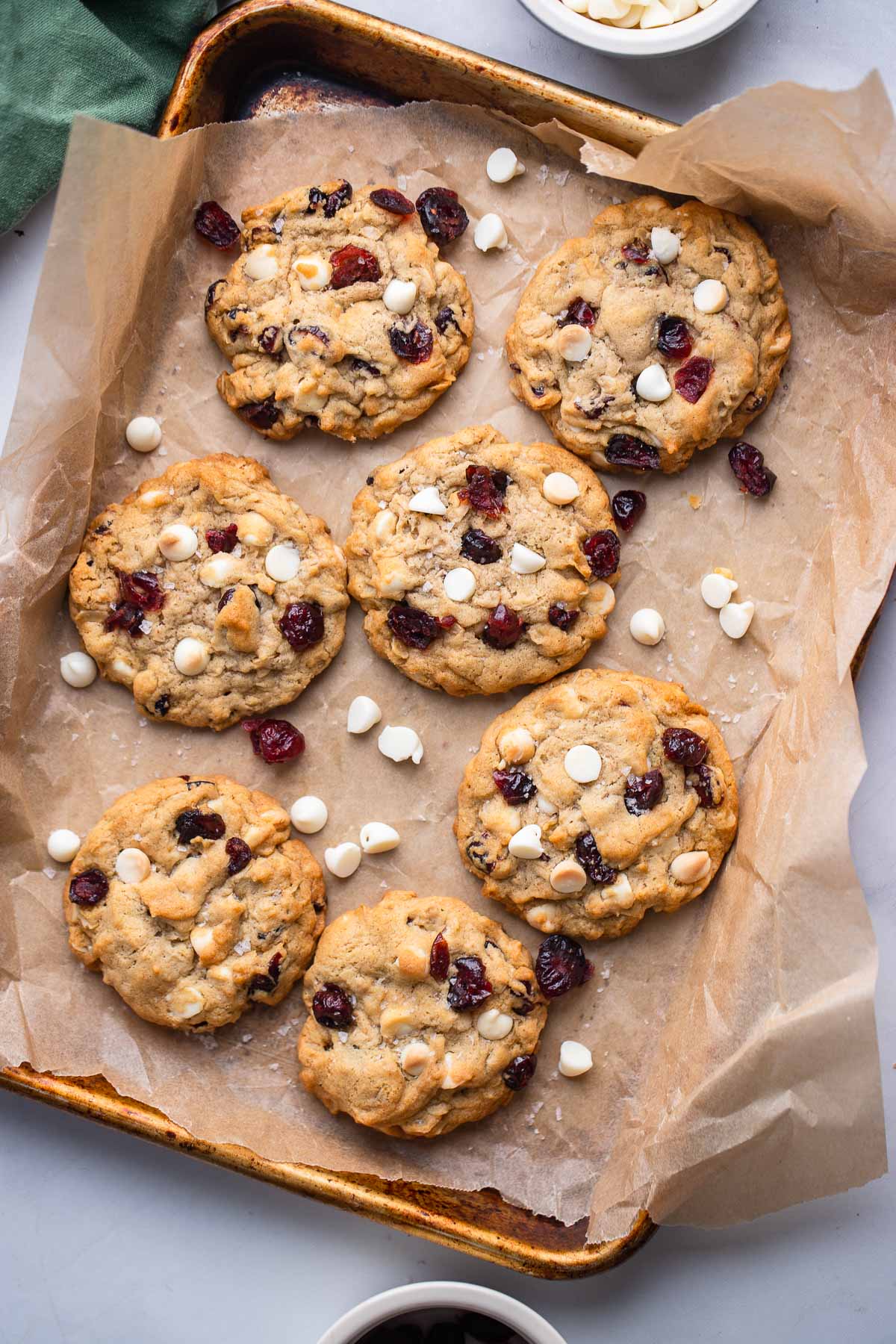 white chocolate cranberry oatmeal cookies on baking sheet with parchment paper.