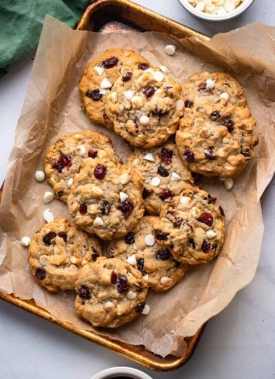 white chocolate cranberry oatmeal cookies on baking sheet lined with parchment paper.