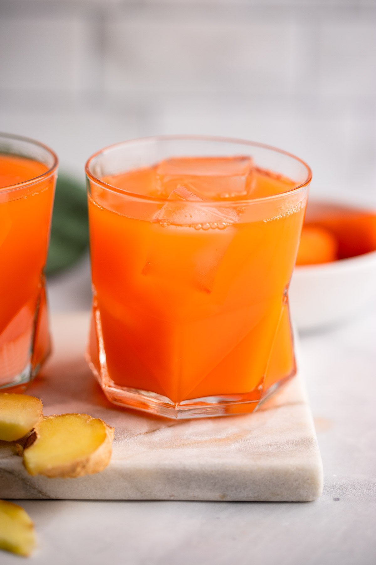 carrot ginger juice in a glass with ice.