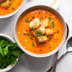 roasted butternut squash and red pepper soup in bowl with croutons.