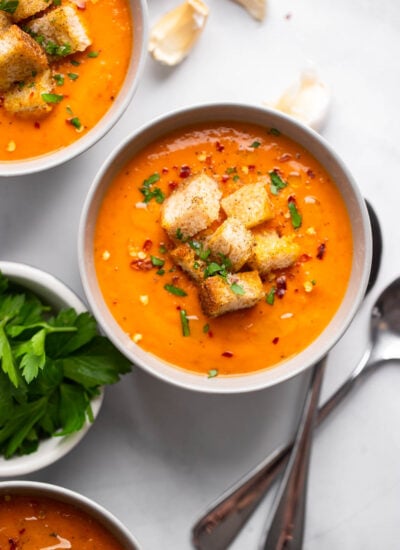 roasted butternut squash and red pepper soup in bowl with croutons.