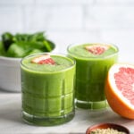 grapefruit green smoothie in glass garnished with slice of grapefruit.