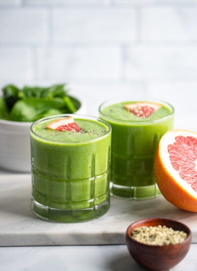 grapefruit green smoothie in glass garnished with slice of grapefruit.