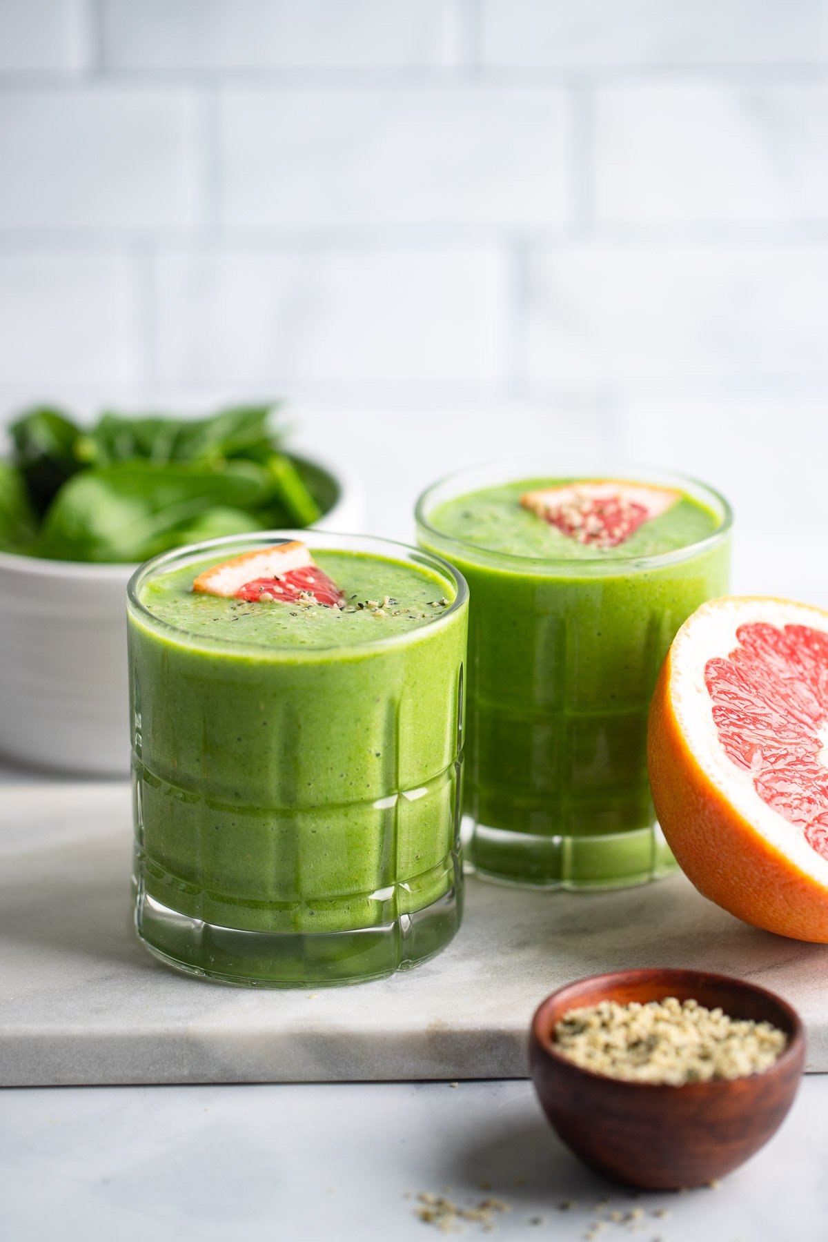 grapefruit green smoothie in glass with wedge of grapefruit for garnish.