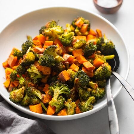 roasted sweet potatoes and broccoli in bowl with spoon.