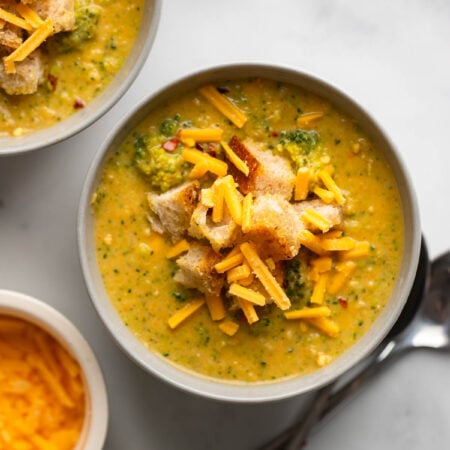 vegan broccoli cheddar soup in bowl garnished with croutons.