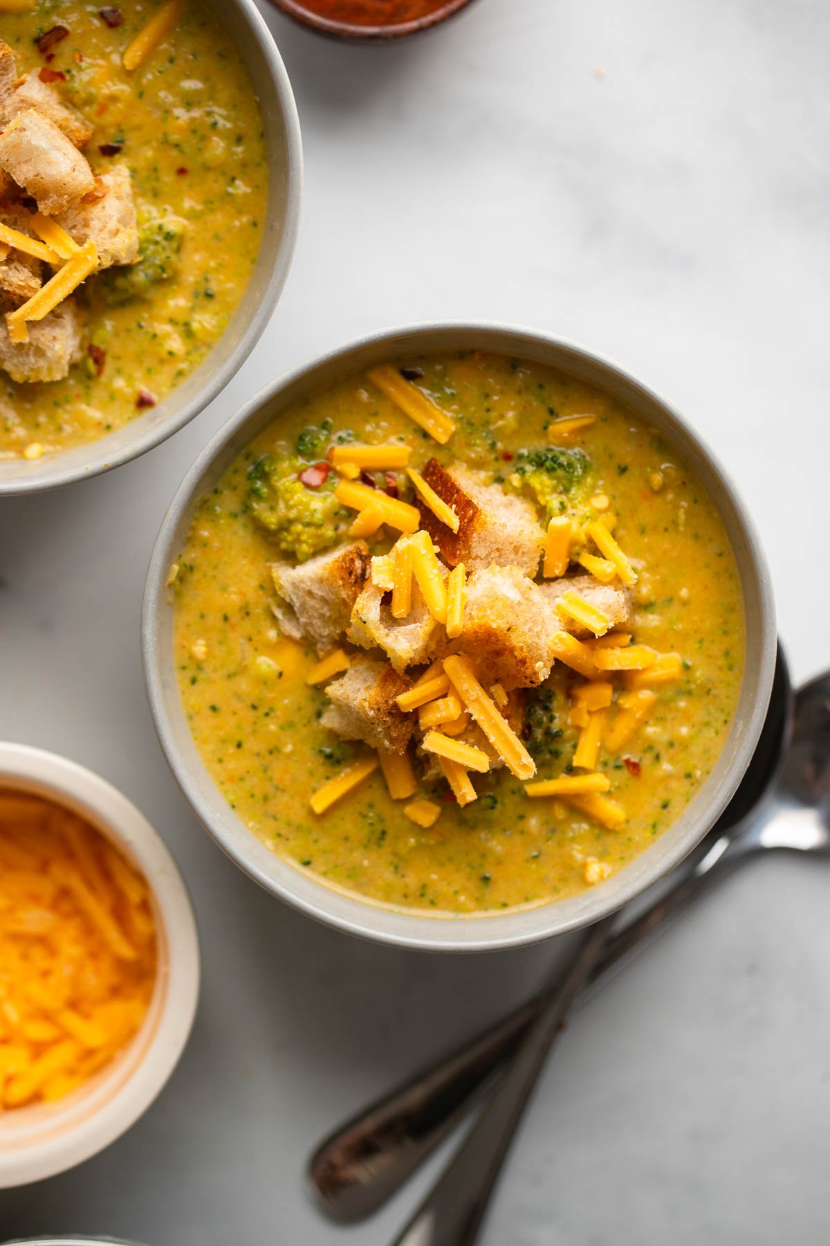 vegan broccoli cheddar soup in bowl garnished with croutons.