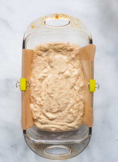 lemon loaf batter in loaf pan lined with parchment paper. 