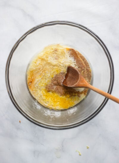 wet lemon loaf ingredients in mixing bowl with wooden spoon.