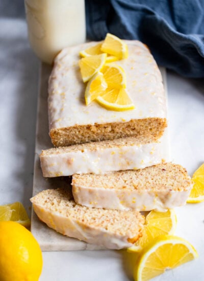 vegan lemon loaf cake with glaze added and lemon slices. 