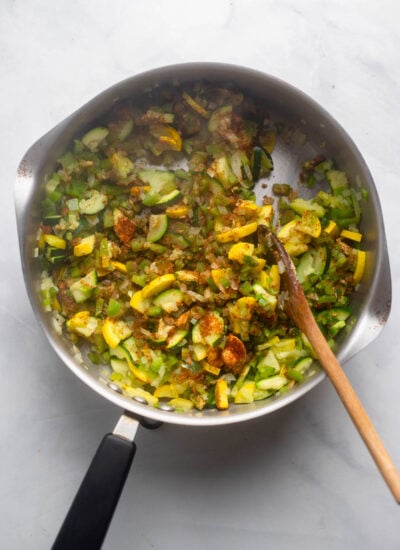 zucchini, onion, and spices sautéed in a skillet.
