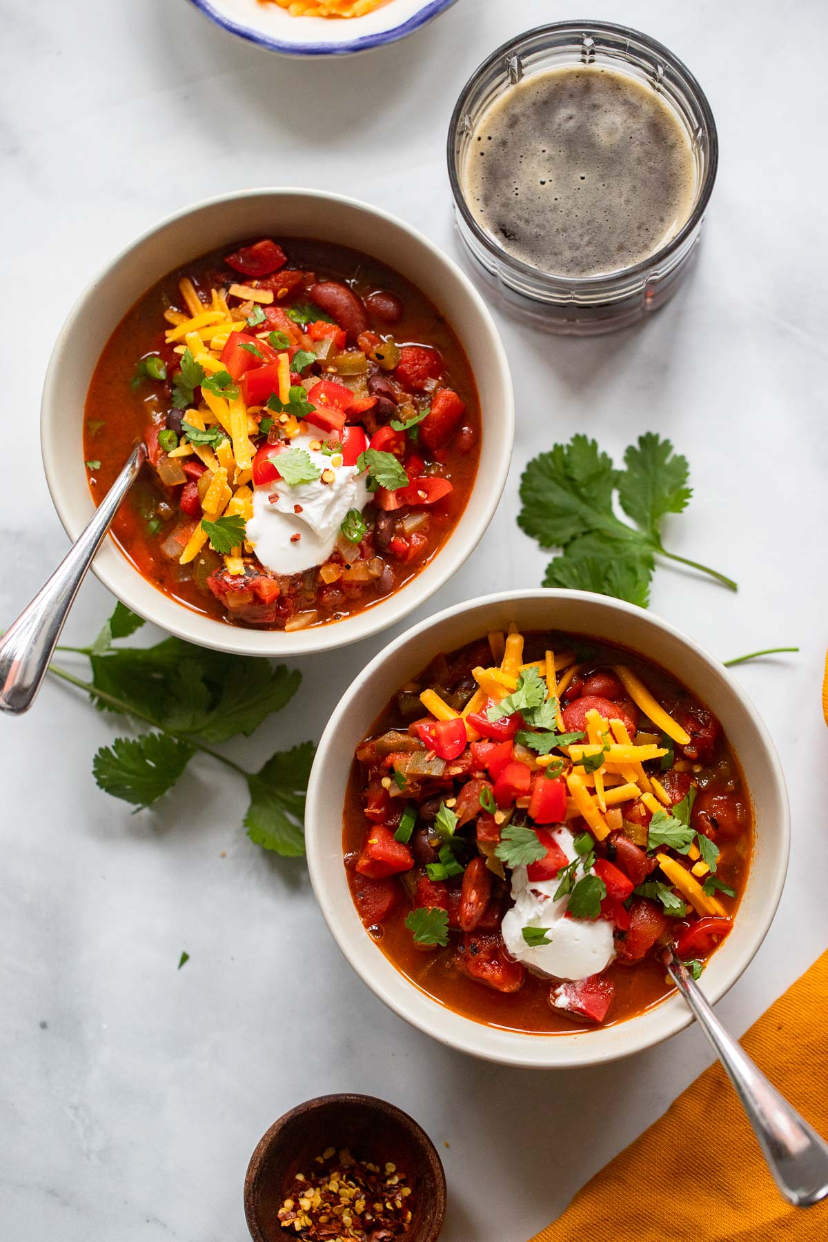 chipotle chili in bowls garnished with sour cream, tomatoes, and cheese. 