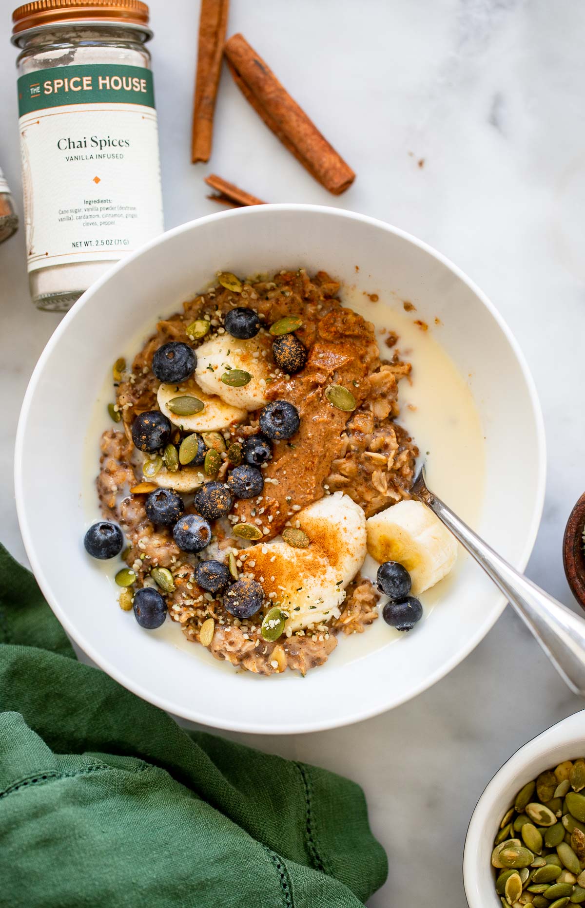 chia spiced oatmeal in bowl garnished with blueberries, sliced bananas, and pumpkin seeds.