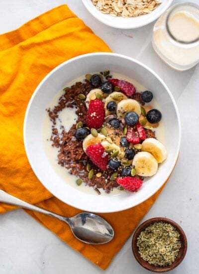 chocolate oatmeal in bowl topped with fresh berries and sliced banana.