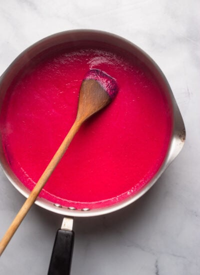 creamy beet sauce in large saucepan with a wooden spoon.