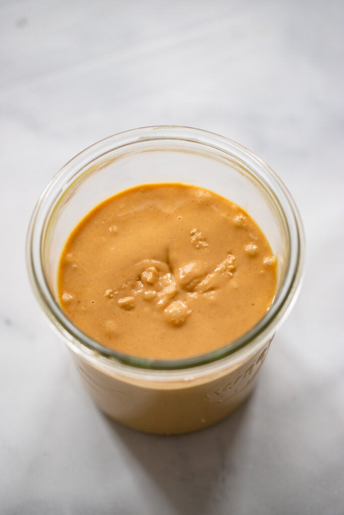 homemade creamy peanut butter in a glass jar. 