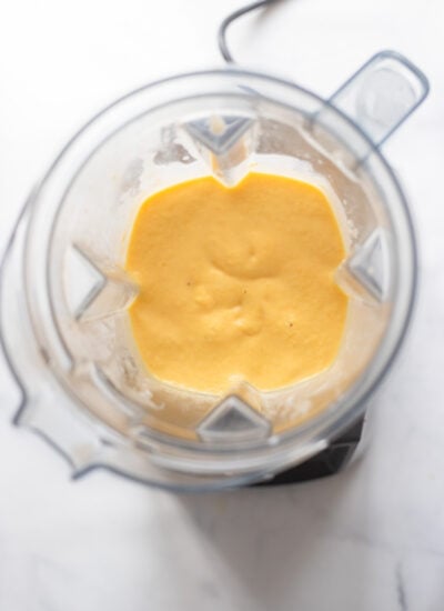 pureed mango turmeric smoothie in blender pitcher.