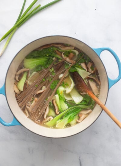 dutch oven with broth and bok choy added with the uncooked soba noodles. 
