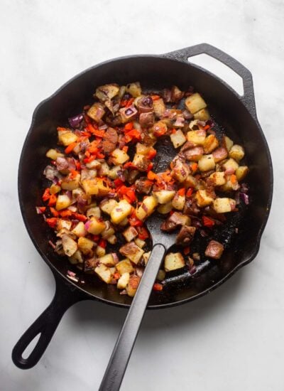 diced potatoes sauteed with red onion and pepper in a cast iron pan. 