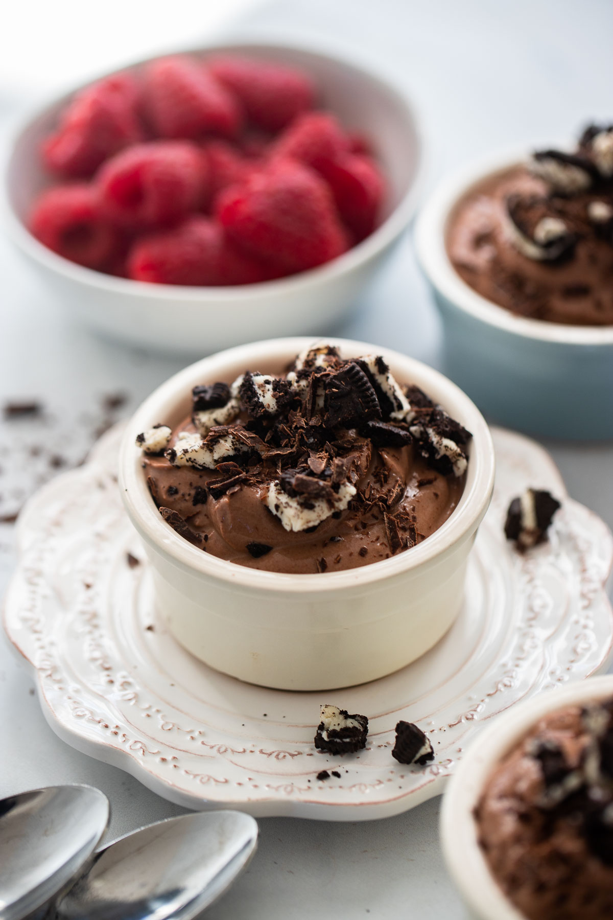 chocolate tofu mousse in a ramekin with crumbled chocolate cookies and shaved chocolate for garnish.