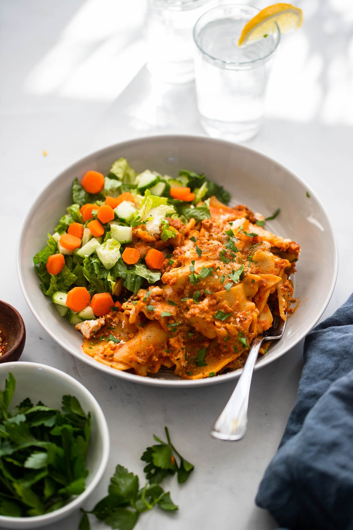 vegan skillet lasagna dished out onto a plate with salad on the side.