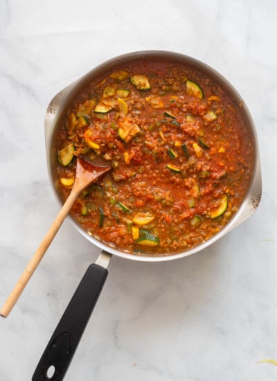 water and pasta sauce added to the veggies and vegan ground beef in a skillet. 