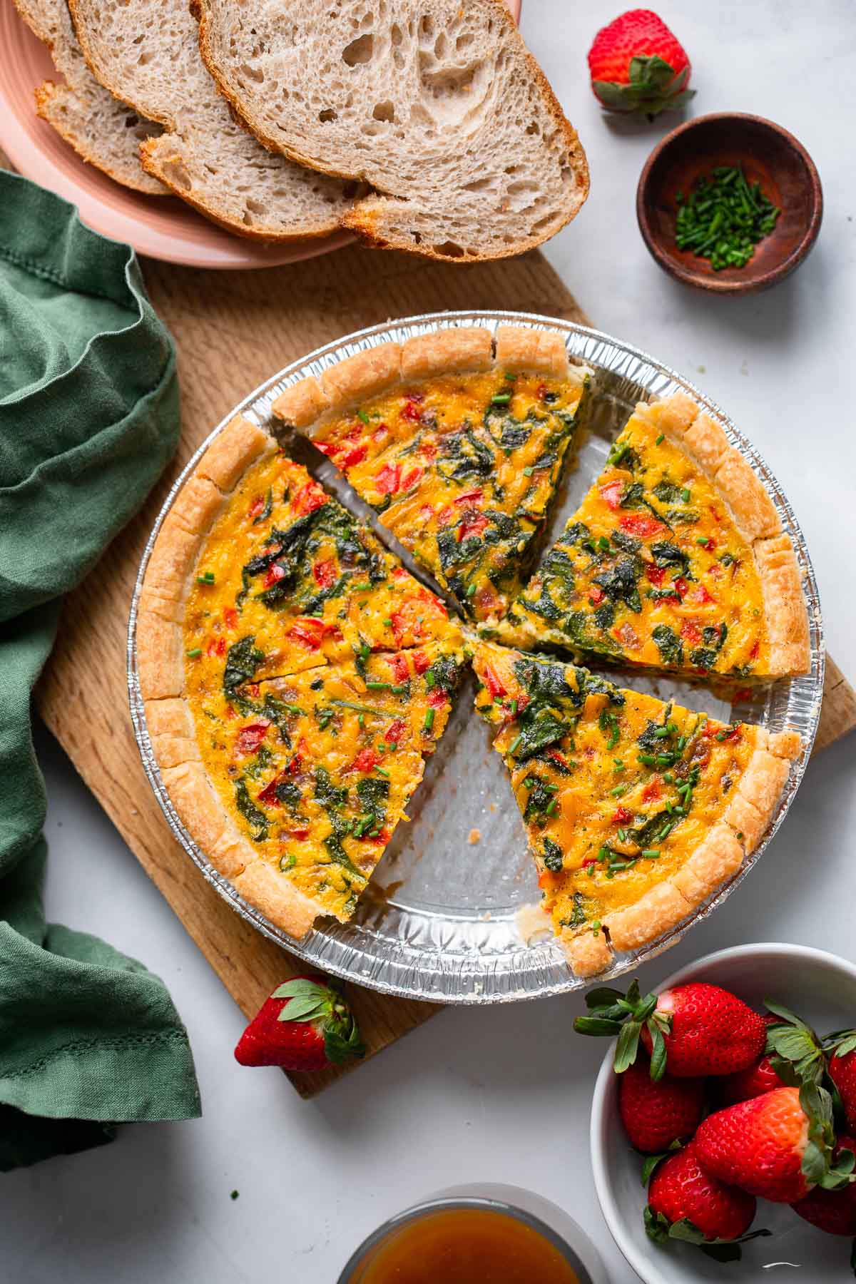 vegan JUST egg quiche in aluminum baking pan with slice removed.