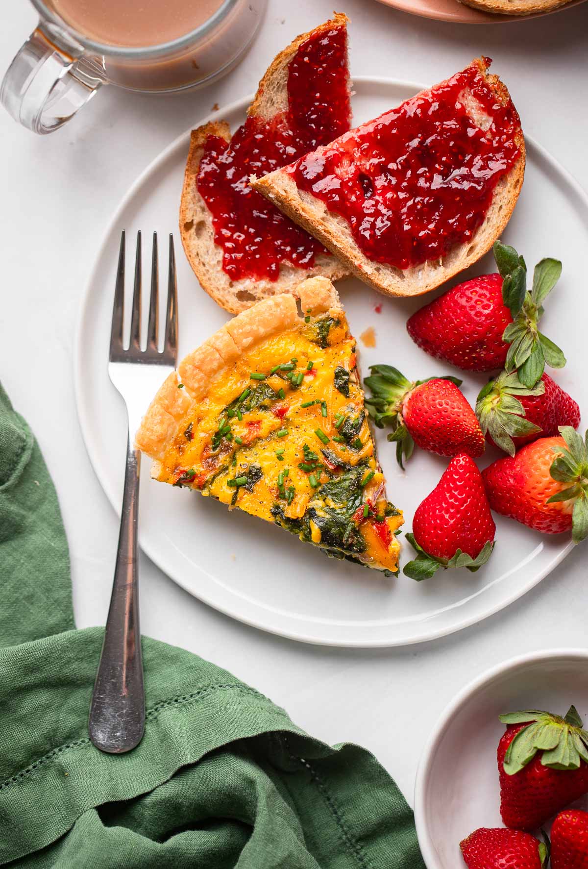 slice of vegan JUST egg quiche on plate with a slice of toast with jam.