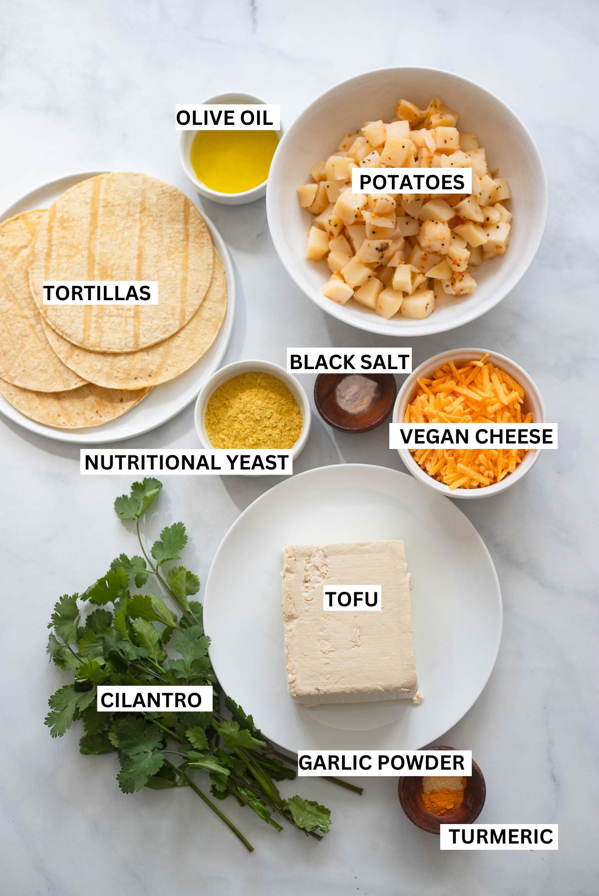 vegan breakfast taco ingredients on a white background with text overlay that says: olive oil, potatoes, tortillas, black salt, cheese, nutritional yeast, tofu, cilantro, garlic powder, and turmeric. 