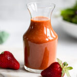 strawberry balsamic dressing in glass dressing container.