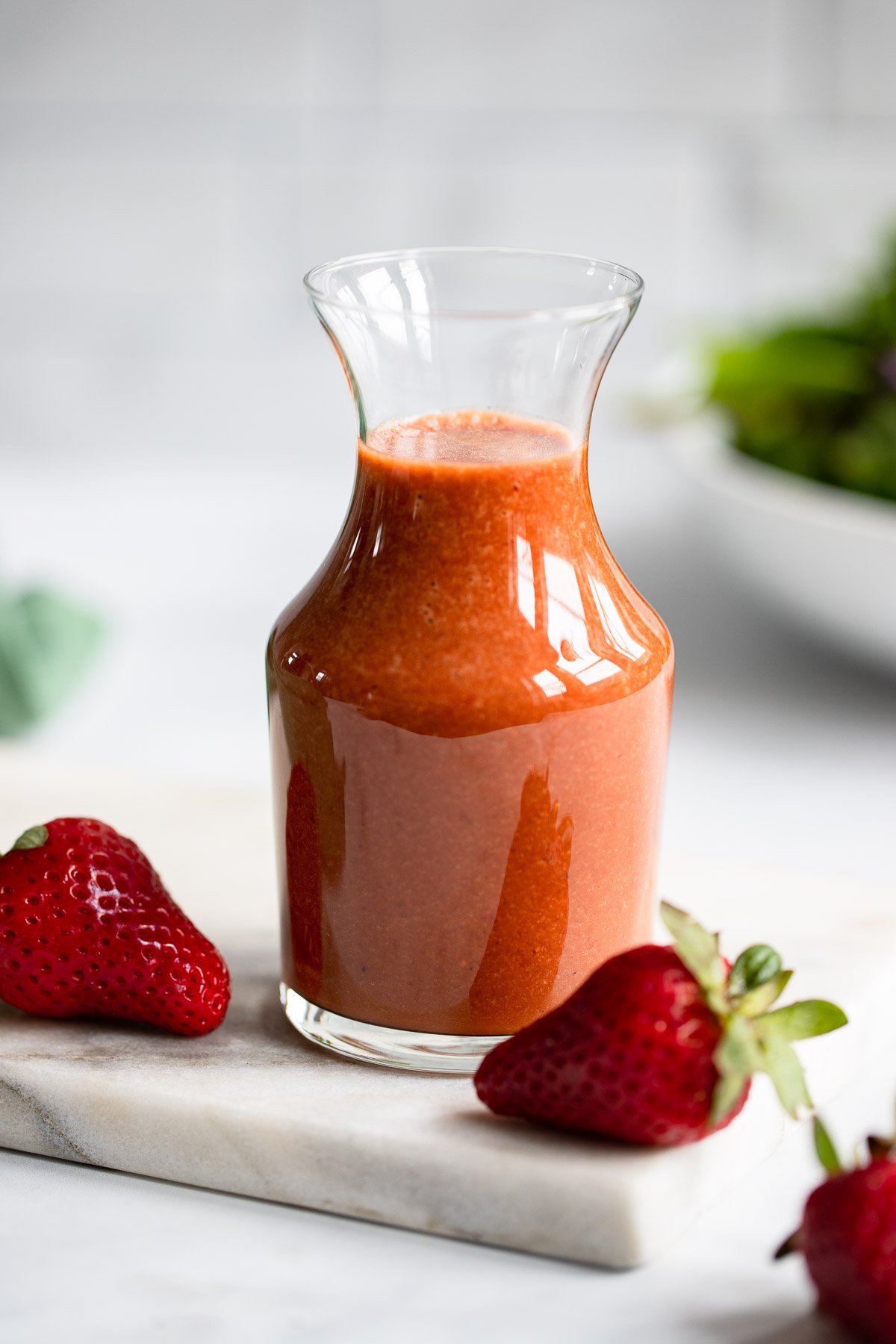 strawberry balsamic dressing in glass serving carafe. 