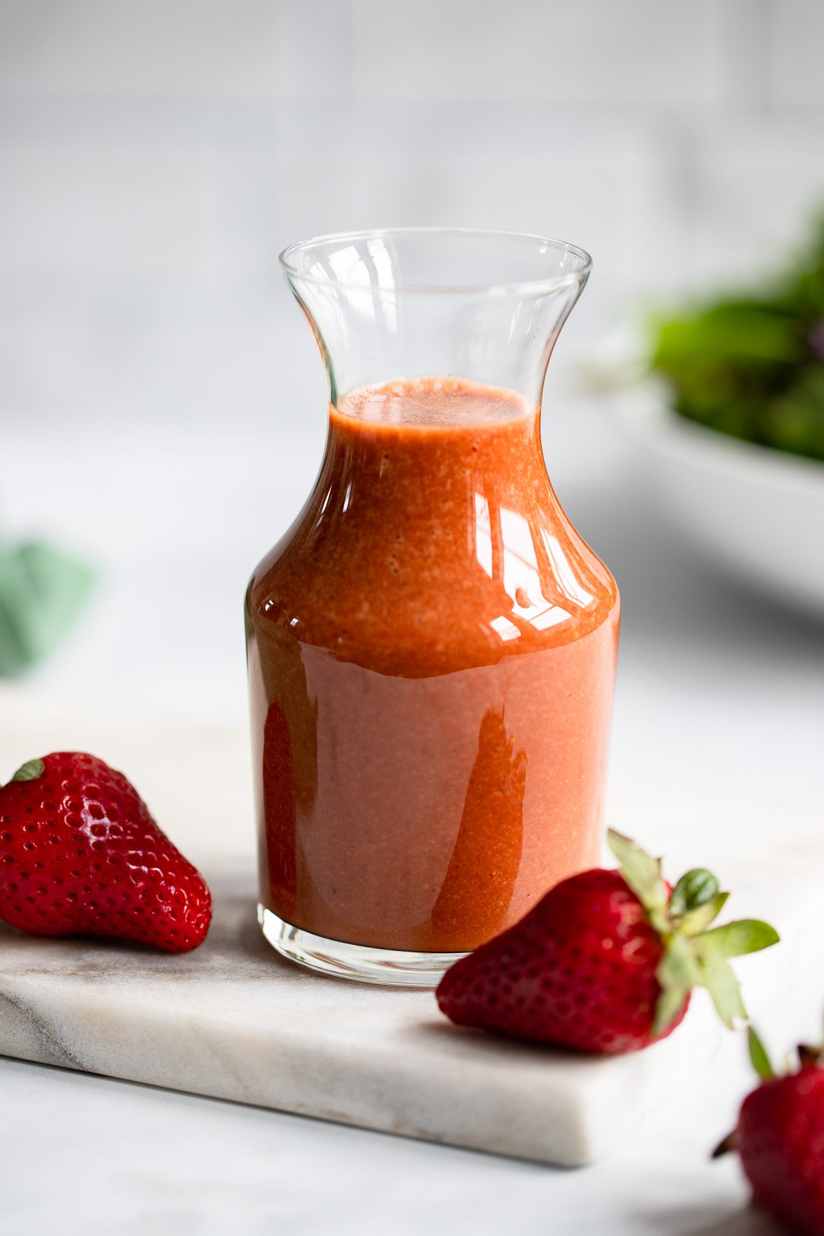 strawberry balsamic dressing in glass dressing container.