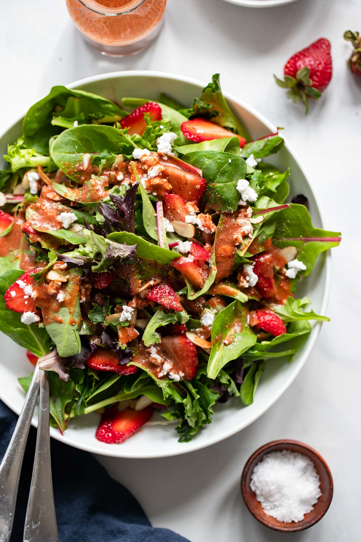 strawberry balsamic dressing on a salad made with spring mix, berries, almonds, feta. 