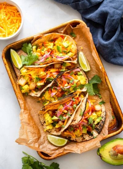 easy vegan breakfast tacos on a pan and garnished with cilantro and red onion.