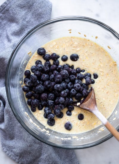 baked oatmeal batter in a mixing bowl with blueberries added.